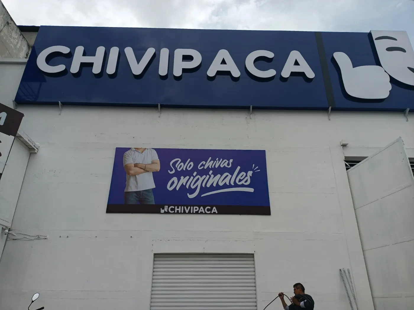 Fachada con letras en relieve y lona tensada en bastidor